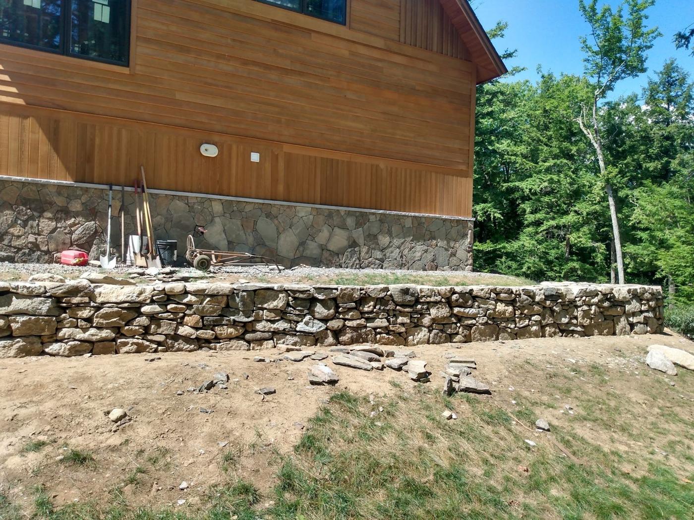 Stone wall along a cedar sided home